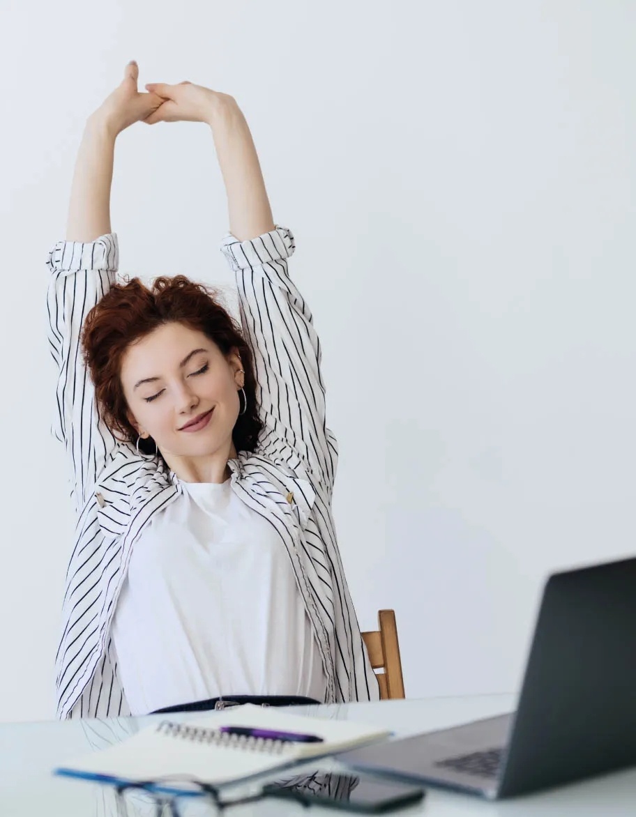 ISO advisor sitting at the desk, and stretching her hands.