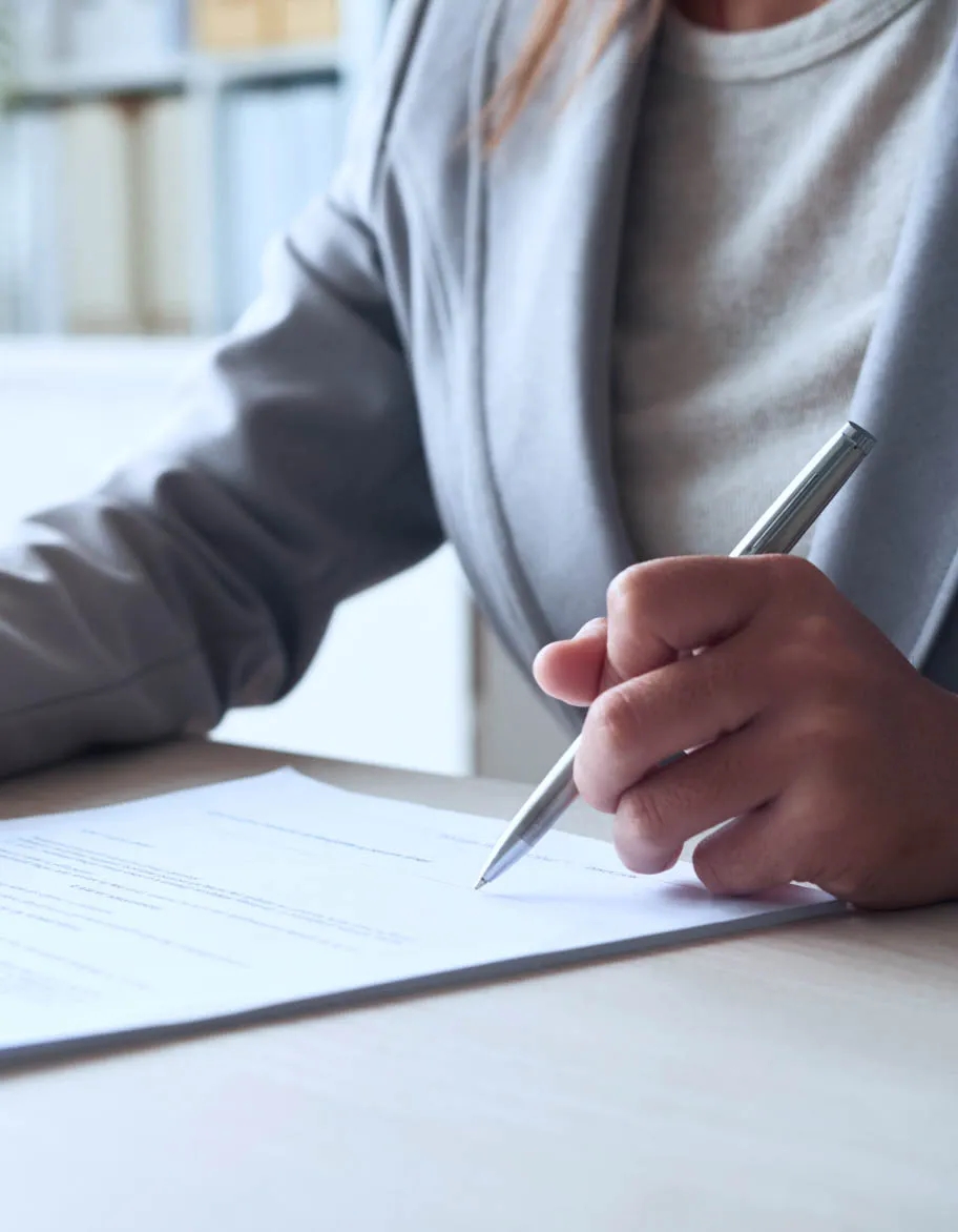 ISO consultant sitting at the desk, signing a contract.