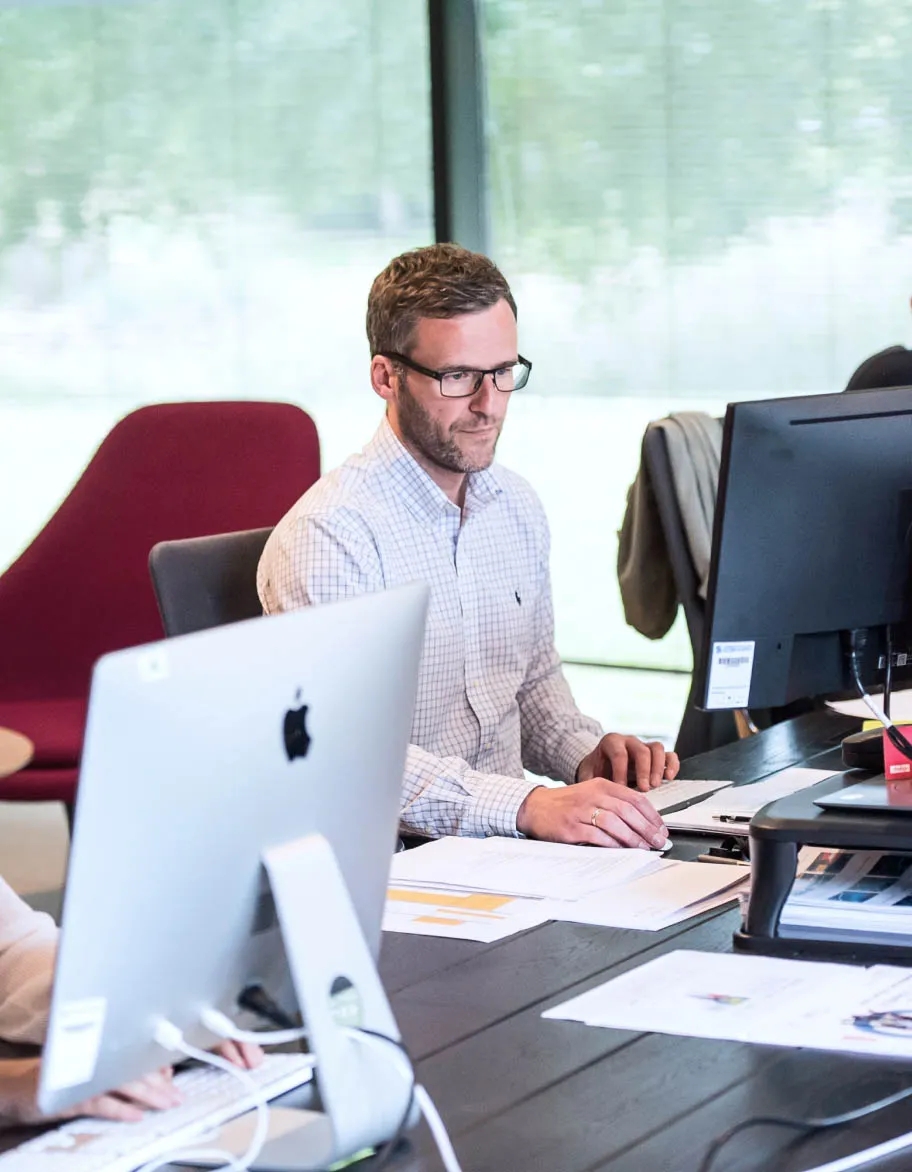 ISO/IEC 27018 consultant sitting in the office, at the desk, working on a project.