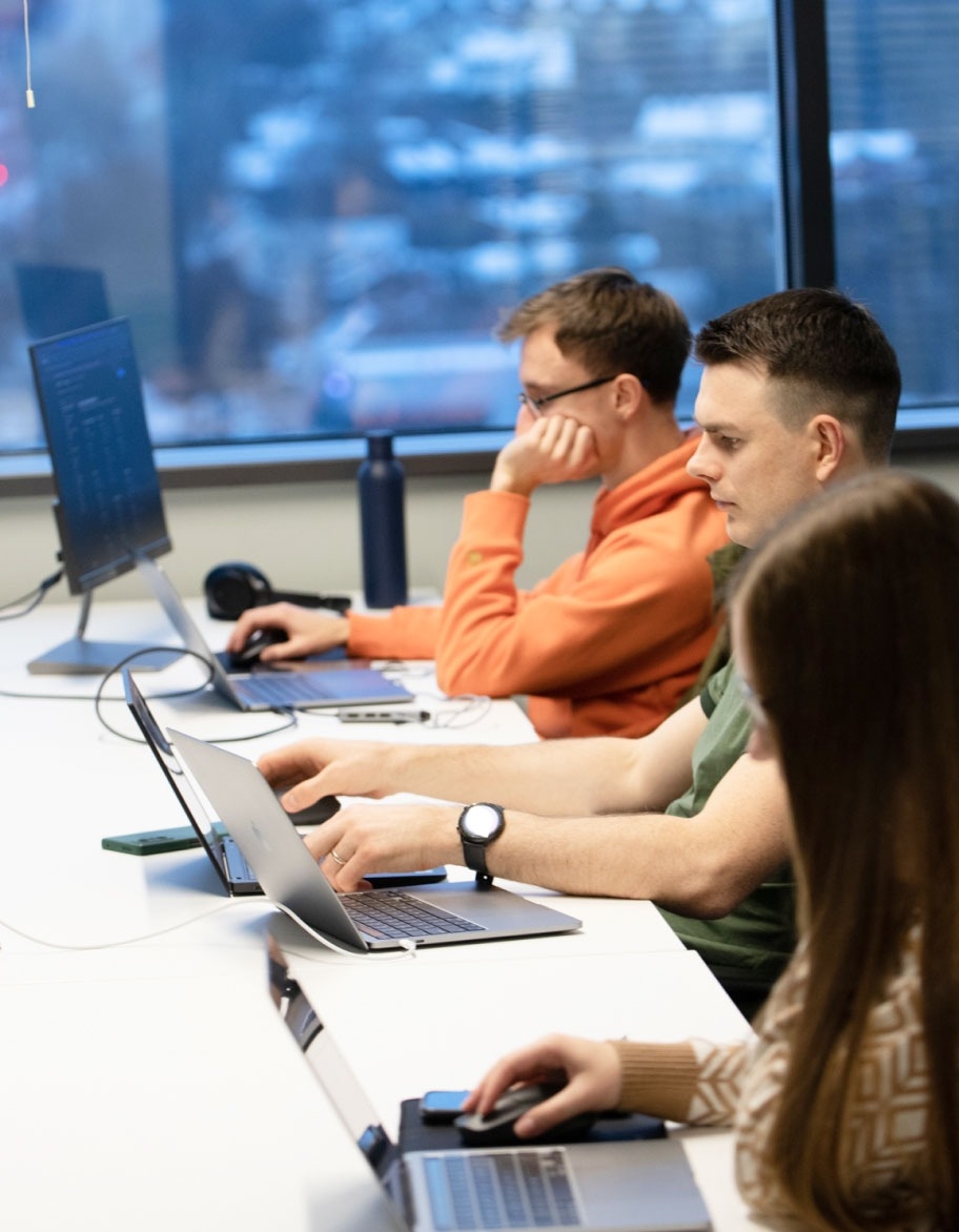 Three persons working with their computers.