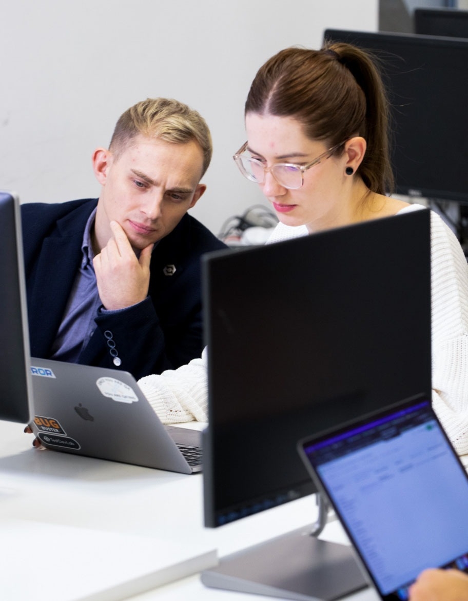 Two ISO advisors looking at the laptop's screen.