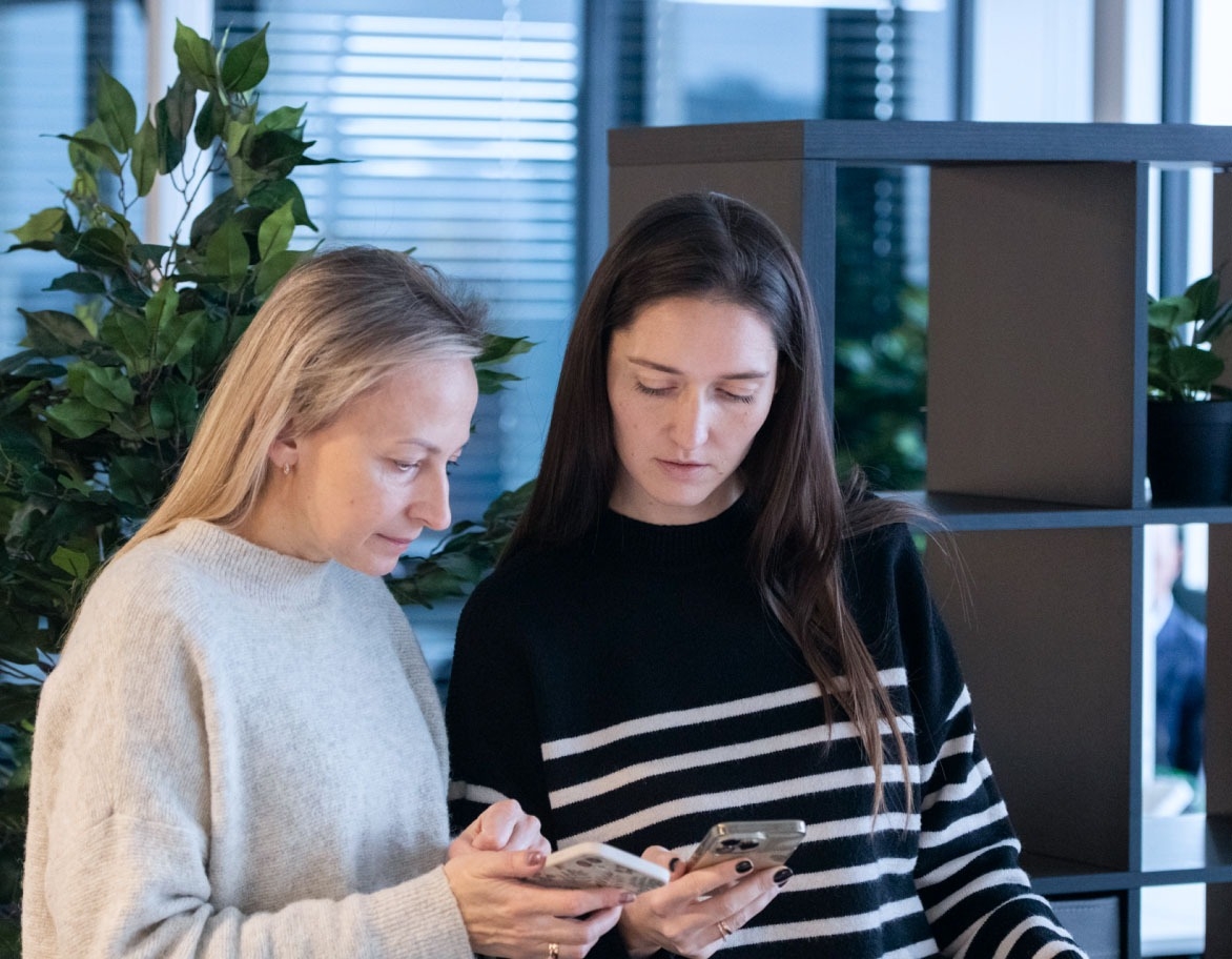 Two persons checking their mobile phones.