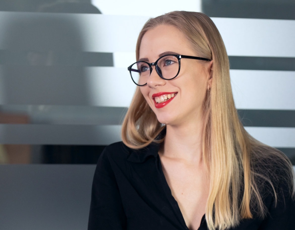 Person sitting in a meeting room and smiling.